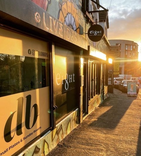 Exterior view of Number 8 at sunset with warm sunlight casting over the building facade, highlighting the venue's signage and creating a welcoming atmosphere.