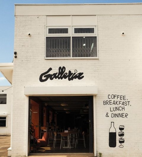 Exterior view of Galleria, a casual dining venue with a white facade, showcasing the restaurant's name and offerings including coffee, breakfast, lunch, and dinner.