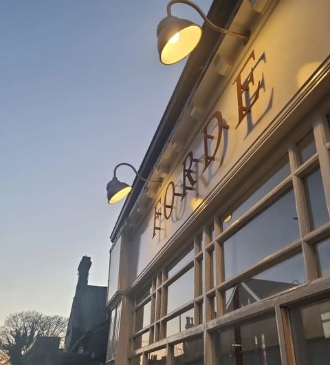 Exterior of a building at dusk with the name "Forde" prominently displayed, illuminated by warm lighting, against a clear sky.