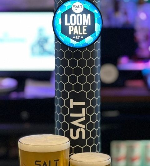 Two pints of beer in front of a SALT brewery tap with illuminated LOOM PALE sign at The Britannia.