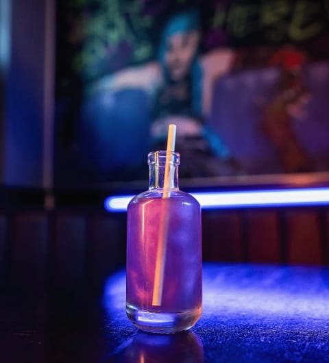 Cocktail in glass bottle on glowing blue LED bar counter at Pixel Bar Leeds