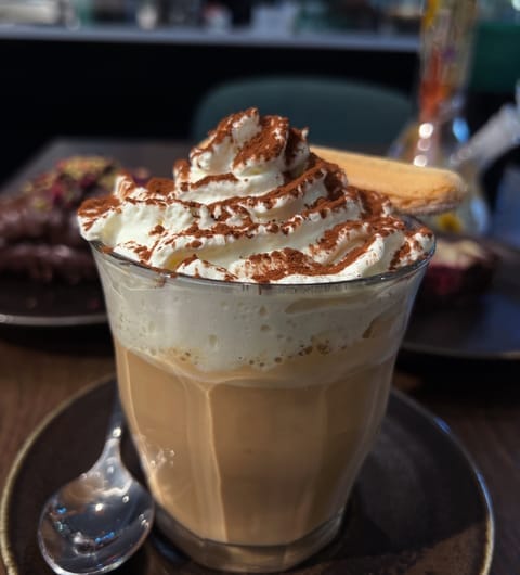 Munch Cafe English Kitchen — whipped cream latte with cocoa dusting
