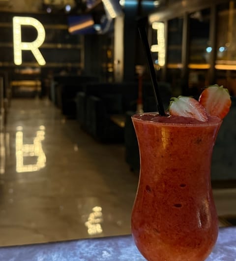 Riviera lounge — red strawberry cocktail in hurricane glass