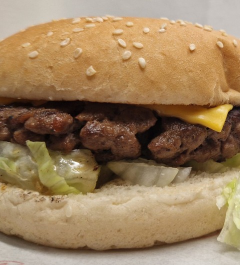 A smash cheeseburger with melted American cheese, lettuce and onion in a sesame bun at Fatbros, Bramley, Leeds.