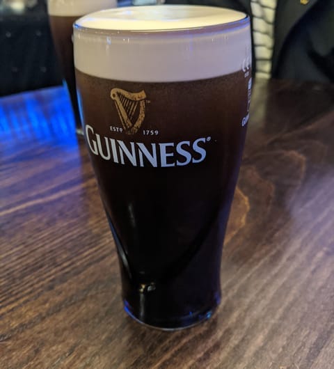 A freshly poured pint of Guinness resting on the wooden bar at The Orchard