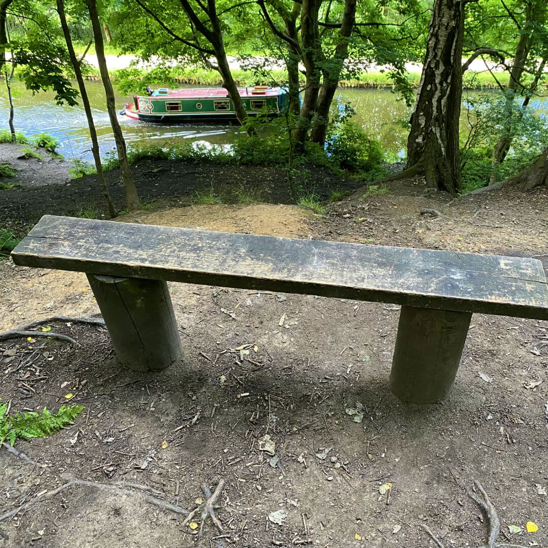 Bramley Fall Woods bench overlooking canal with canal boat