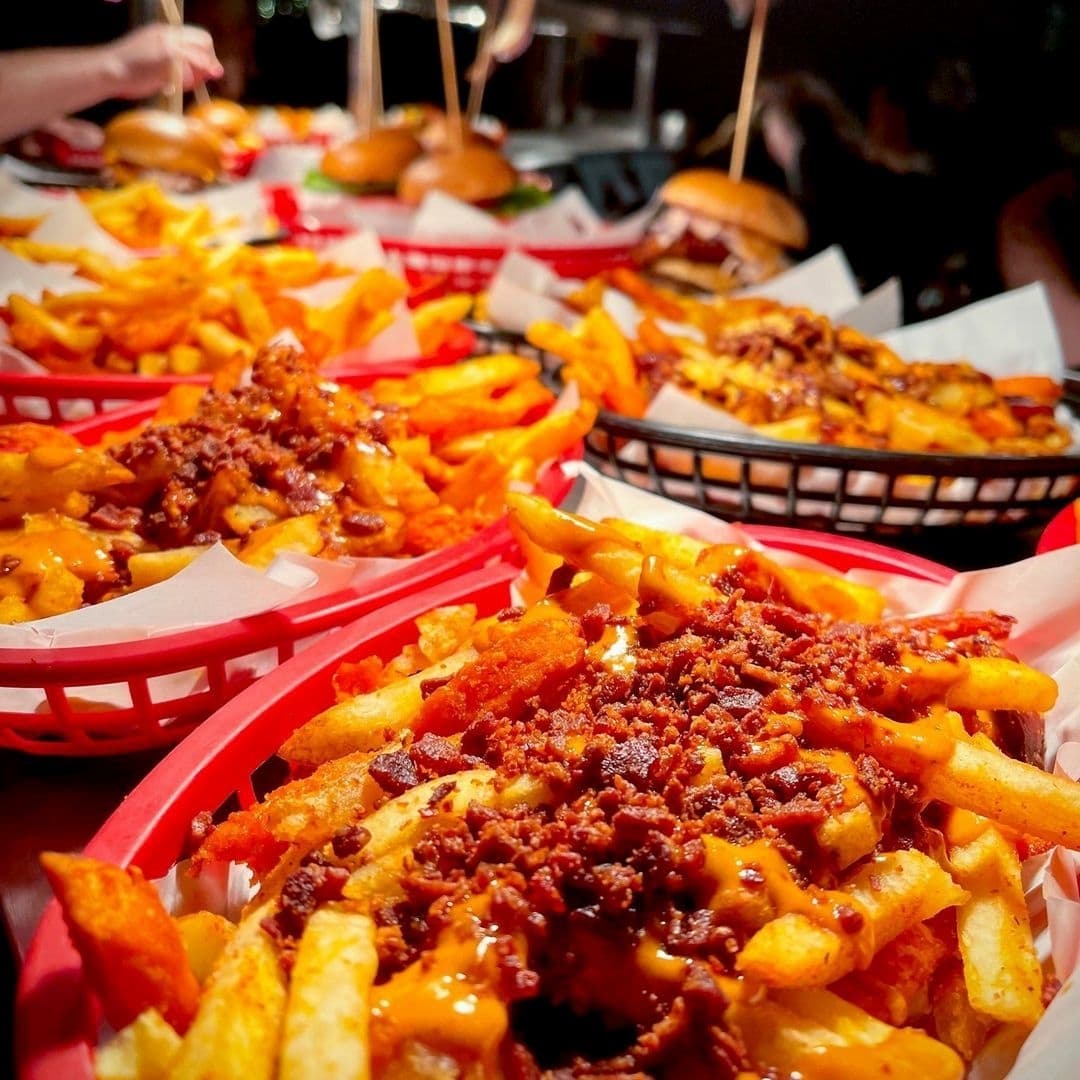 Mouthwatering loaded fries and juicy burgers served at Almost Famous, a vibrant dining destination for food enthusiasts.