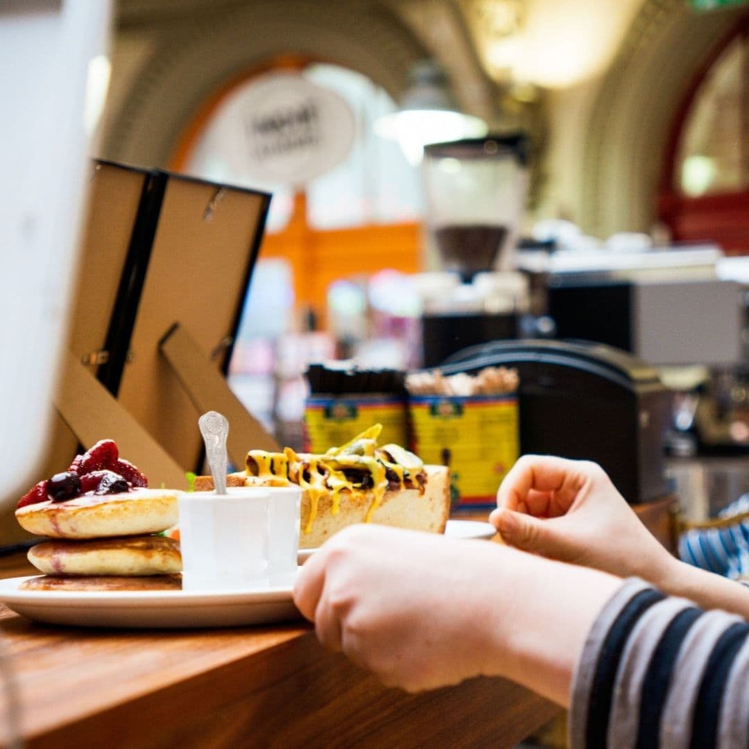 Person enjoying a variety of bruschetta at Bruschetta location with vibrant cafe background.