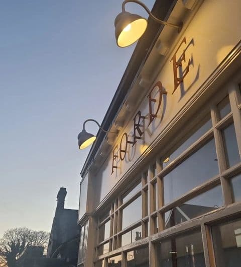 Exterior of a building at dusk with the name "Forde" prominently displayed, illuminated by warm lighting, against a clear sky.