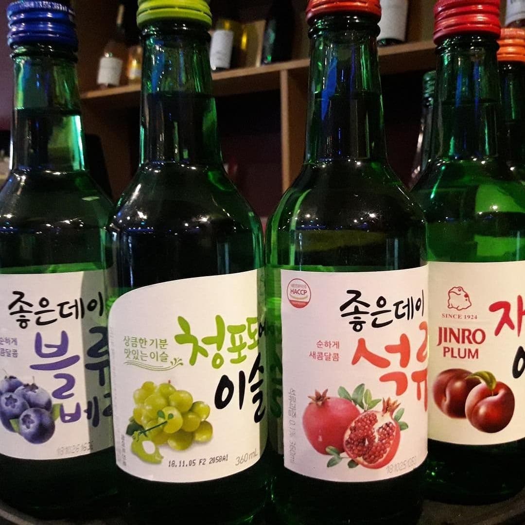 Assorted bottles of Korean soju with fruit flavors on a shelf at Hama Korean BBQ Buffet.