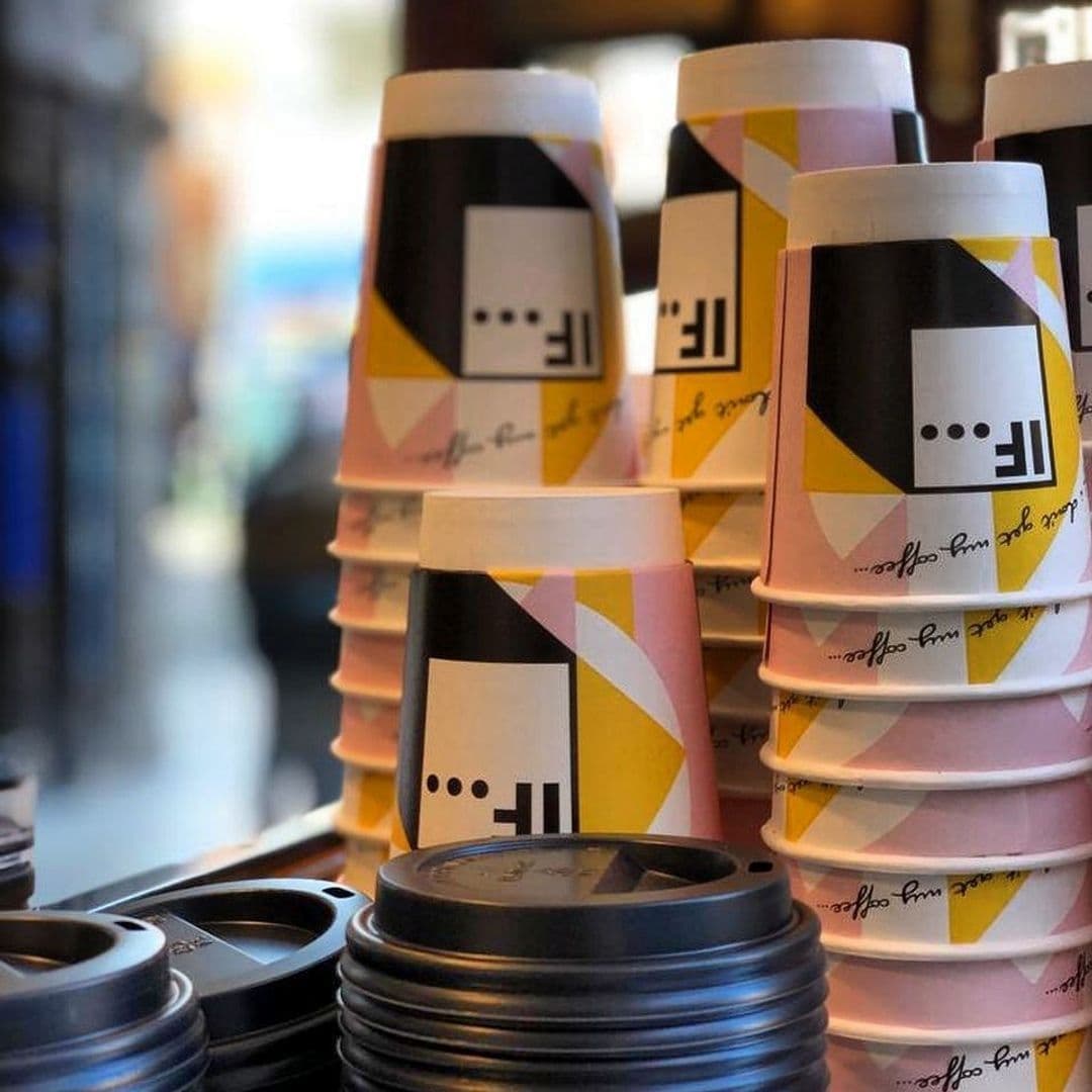 Stacked colorful takeaway coffee cups with modern design at IF Bar – Call Lane.