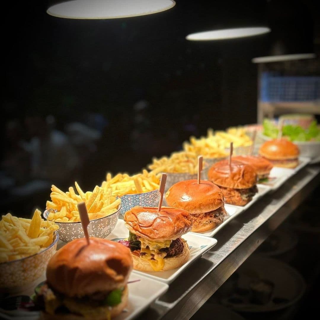 Gourmet burgers and fries served at Mad Frans Bar, highlighted under warm lighting.