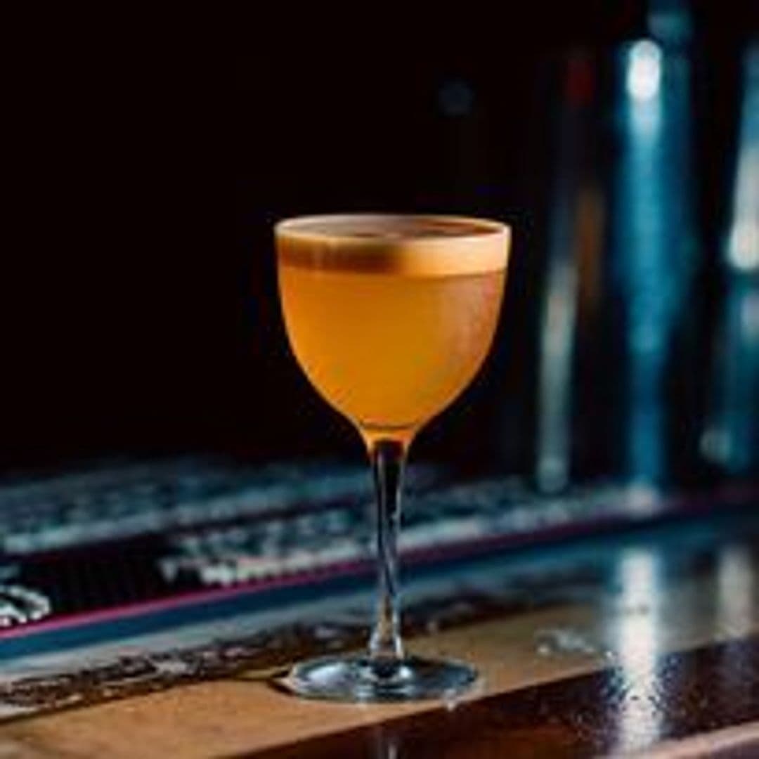 Elegant cocktail glass with amber-colored drink on a bar at Neon Cactus.