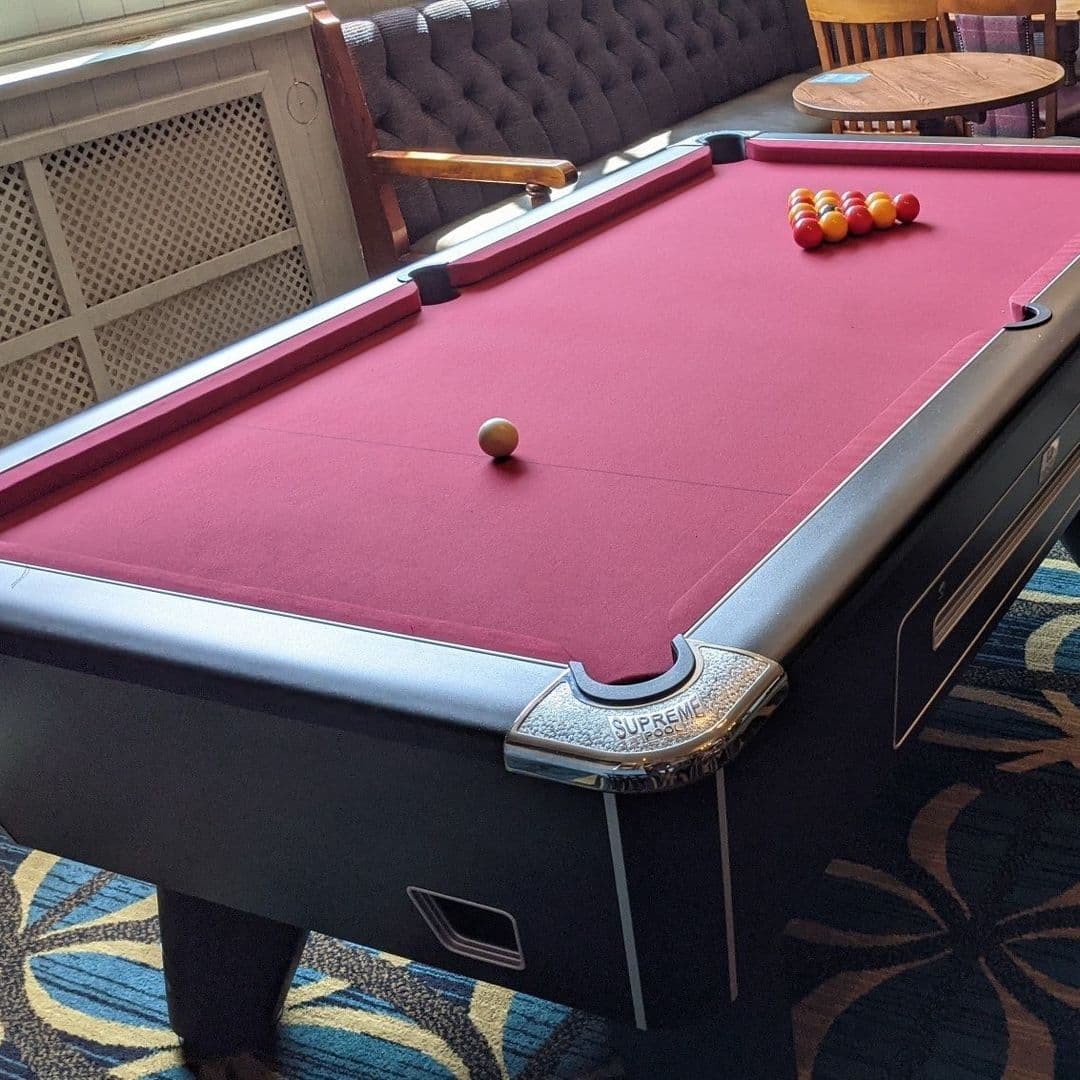 Pool table with red felt and racked balls at The Woodcock New Farnley.