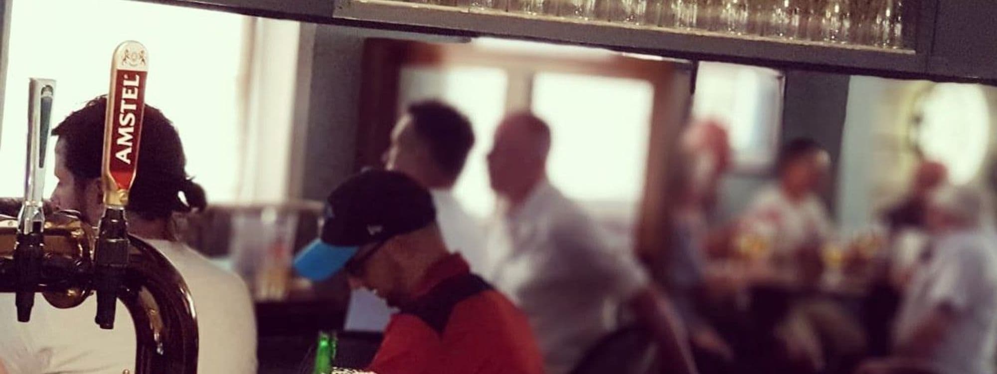 Patrons enjoying a social atmosphere at Two Pointers with a focus on a beer tap in the foreground.