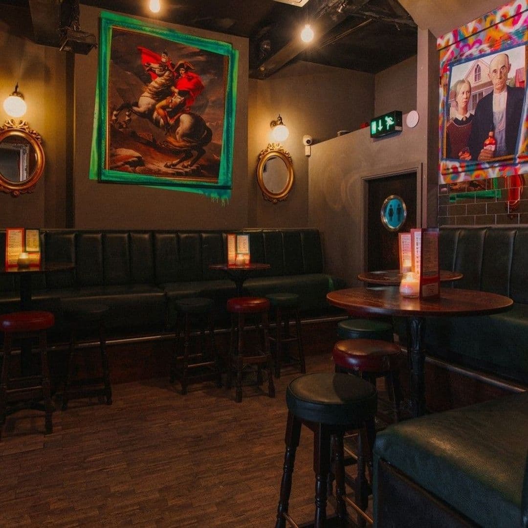 Interior of Call Lane Social with cozy seating, artwork on walls, and warm lighting.