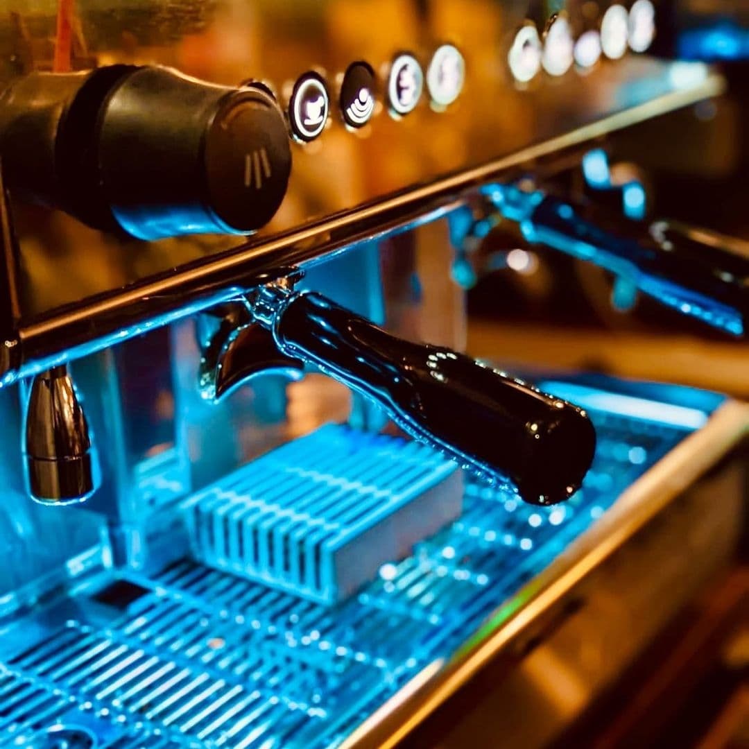 Close-up of a shiny espresso machine with taps at Ilkley Moor Vaults, highlighting the venue's modern coffee-making facilities.