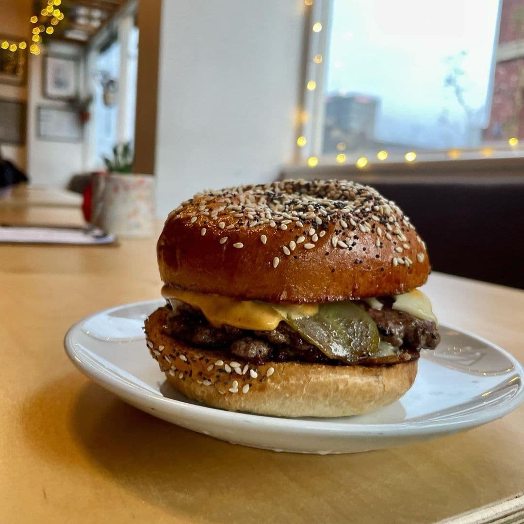 Juicy cheeseburger with sesame bun on a white plate at The Brunswick.