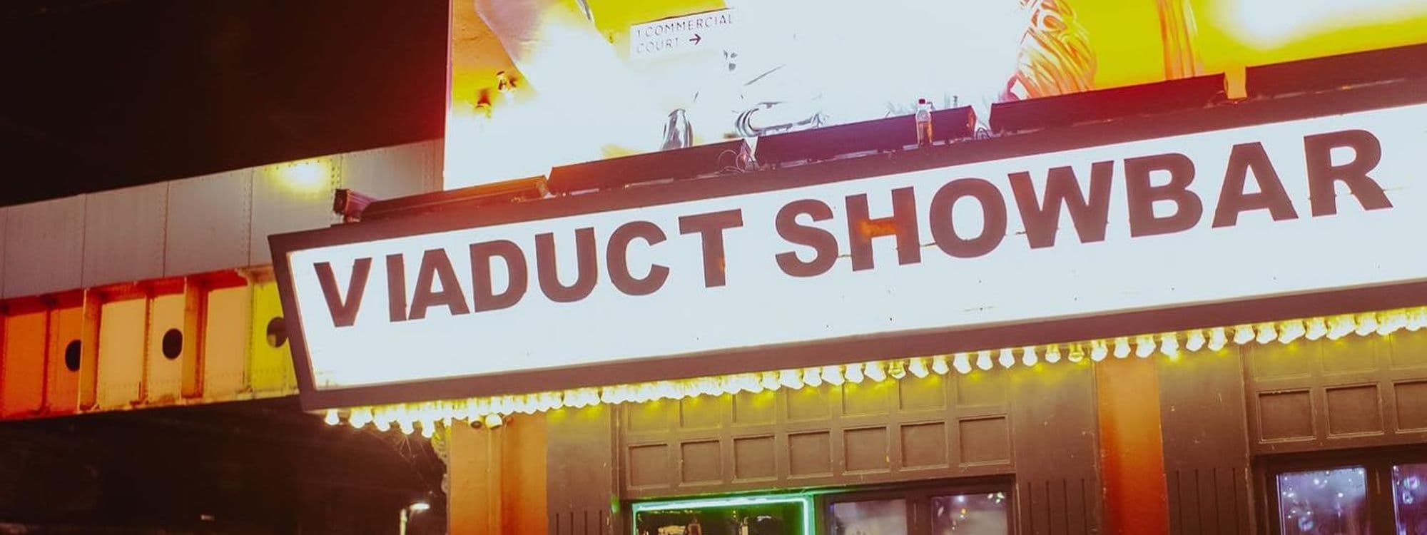 Illuminated sign of Viaduct Showbar with bright lights at night.
