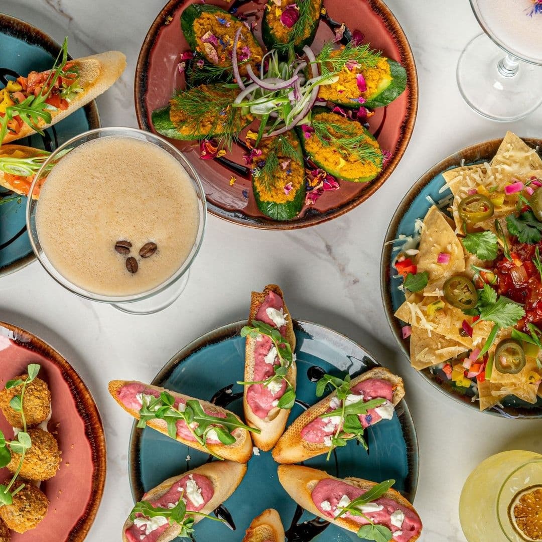 Assorted gourmet appetizers and cocktails on marble table at Dirty Martini.