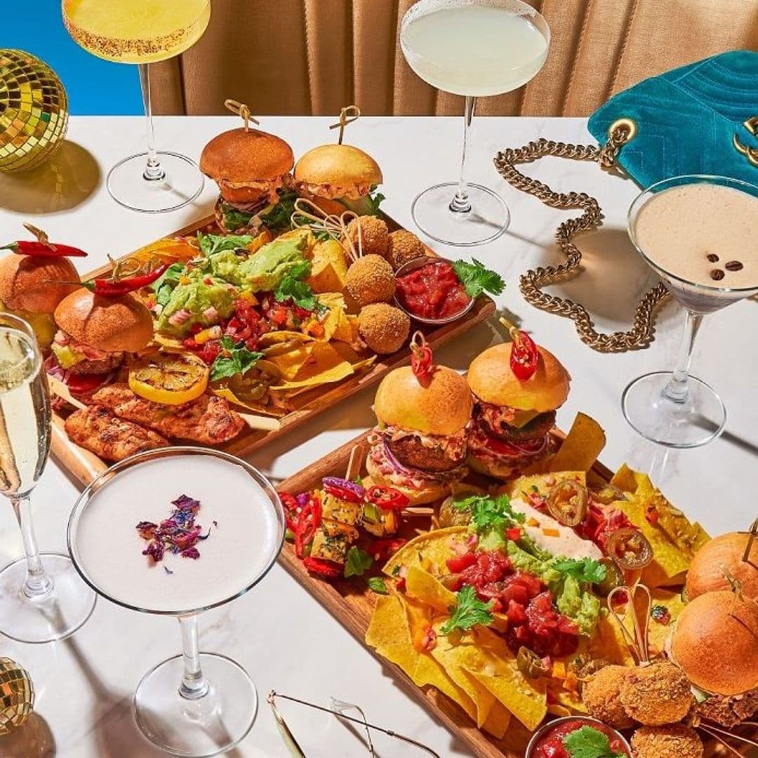 Assorted gourmet appetizers and cocktails at Dirty Martini, featuring sliders, nachos, grilled skewers, and a variety of martinis.