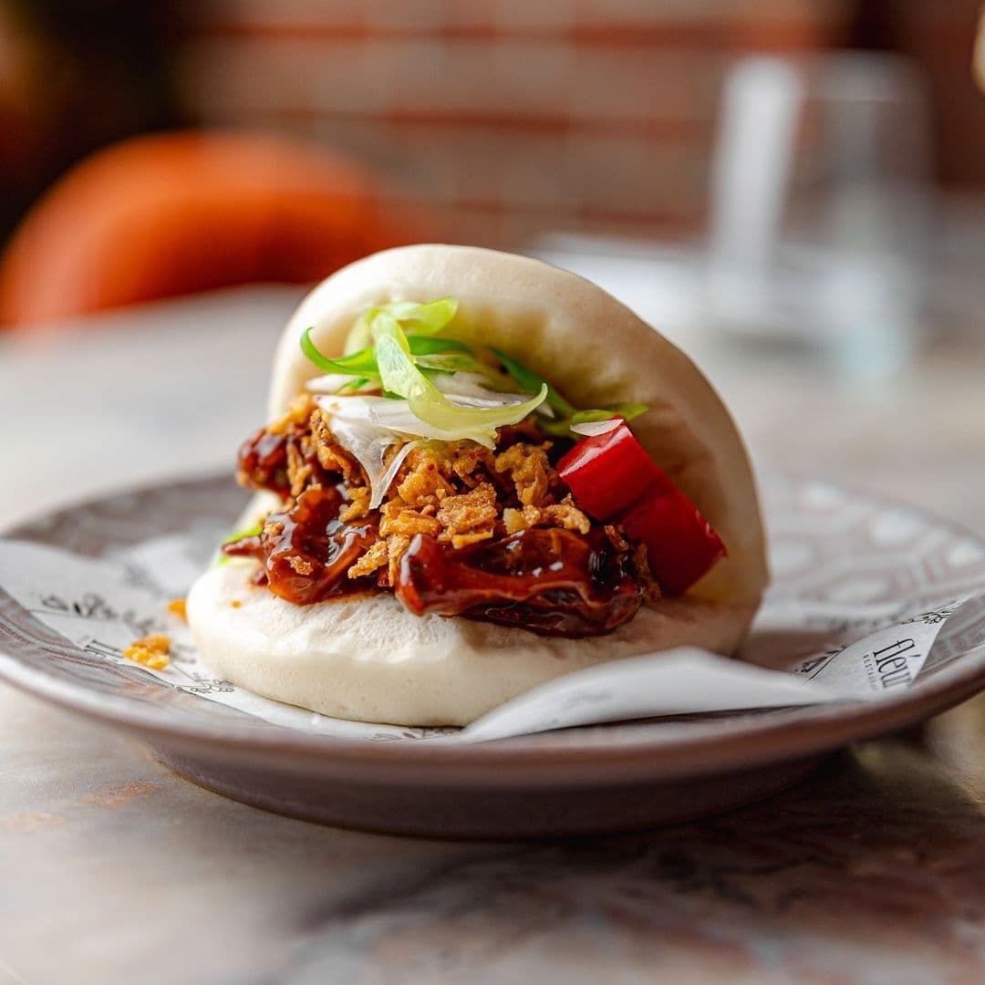 Gourmet pulled pork bao bun served on a ceramic plate at Fleur Restaurant and Bar.