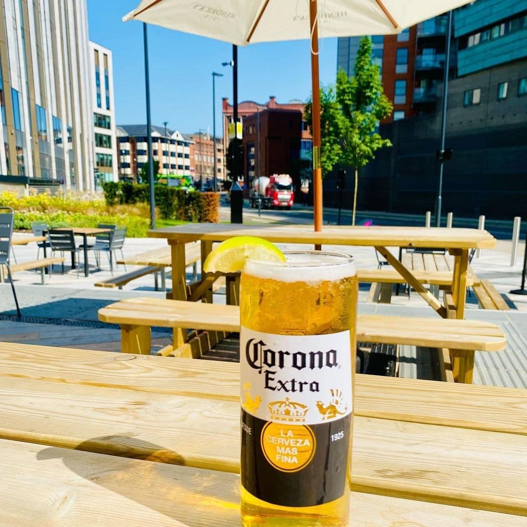 Outdoor seating at Hoist House with a refreshing glass of Corona beer on a sunny day.