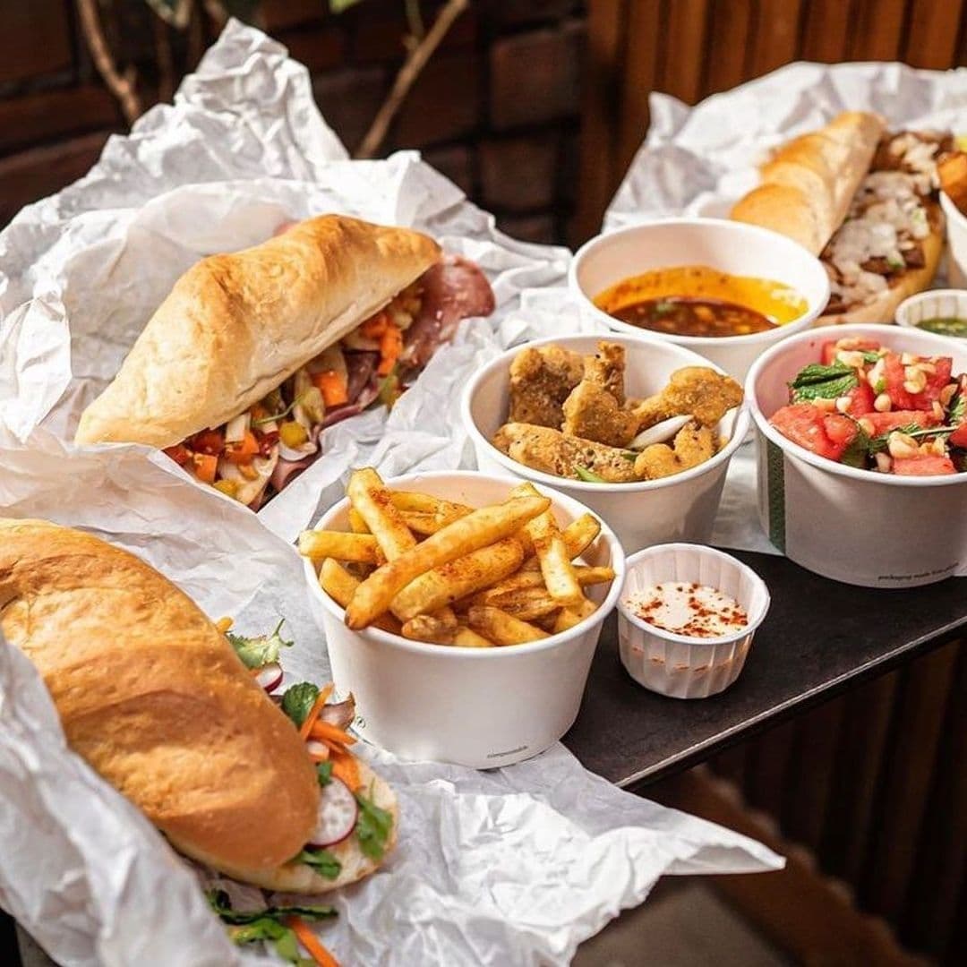 Assorted delicious dishes at Roland's featuring fresh sandwiches, golden fries, seasoned chicken tenders, and a bowl of salad.