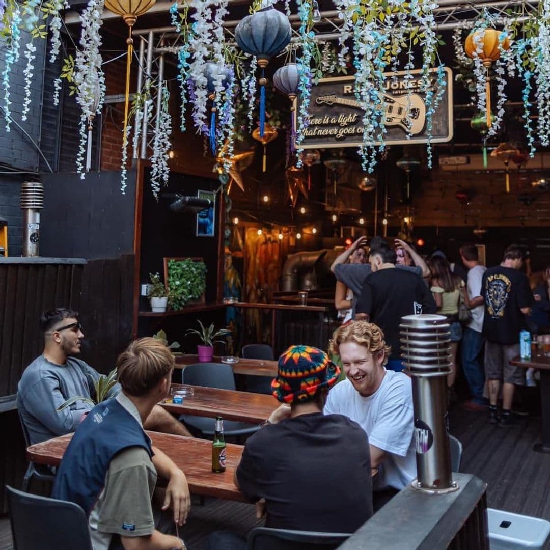 Patrons enjoying a relaxed atmosphere at Distrikt with hanging decorations, ambient lighting, and casual seating.