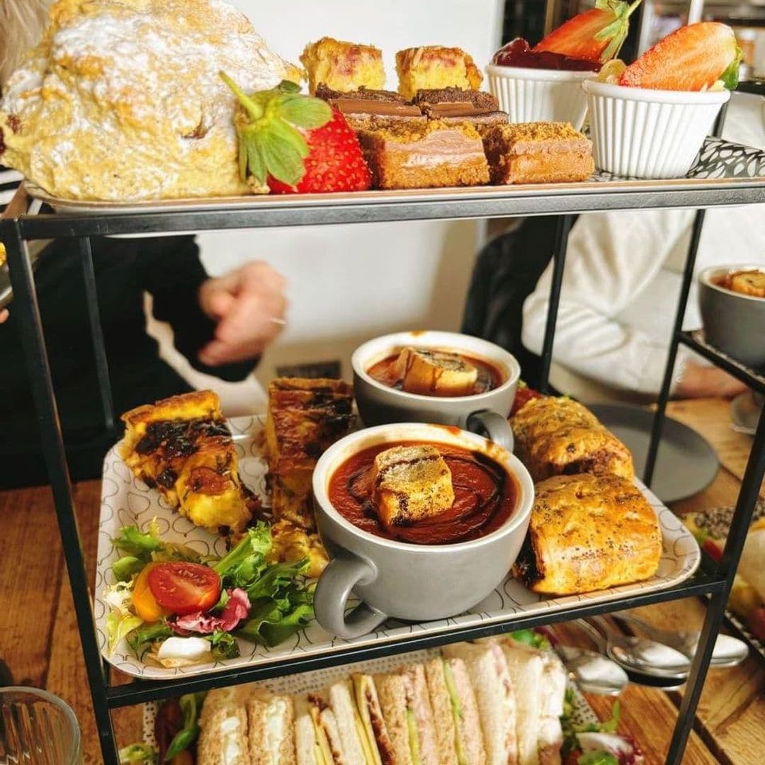 Assorted fresh pastries, sandwiches, and soups on a multi-tiered serving tray at Gray's, showcasing a variety of delicious dining options.