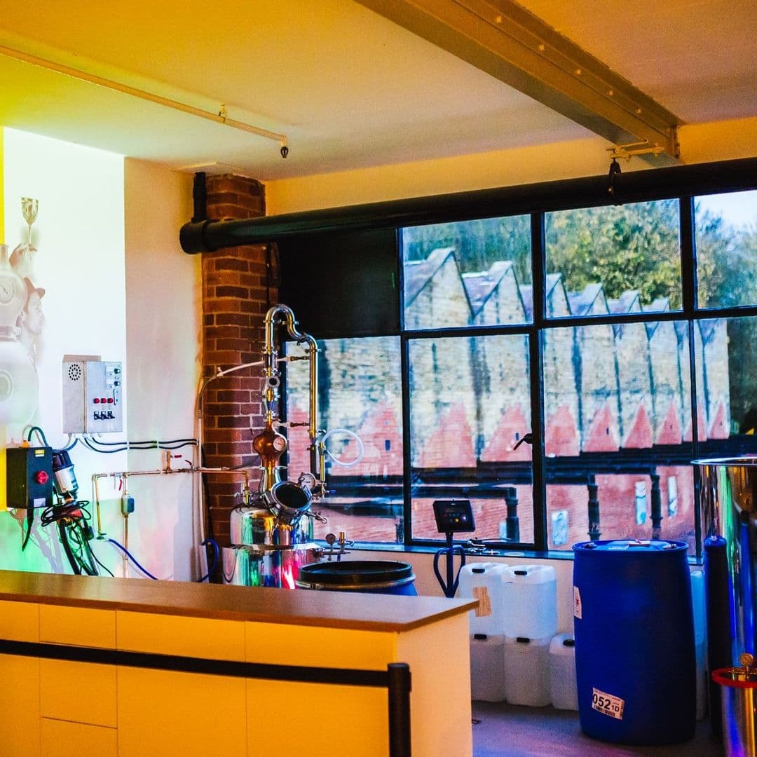 Interior of Test Bar featuring modern brewing equipment with stainless steel fixtures and a view of historic buildings through large windows.