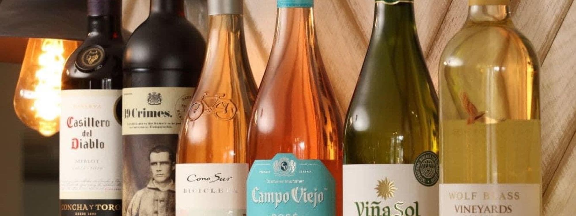 Selection of wine bottles on a shelf at The Brown Cow, showcasing a variety of red, rosé, and white wines with visible labels.