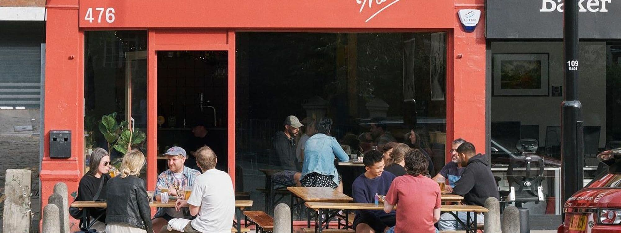 Outdoor seating at The Melbourne cafe with patrons enjoying drinks and conversation.