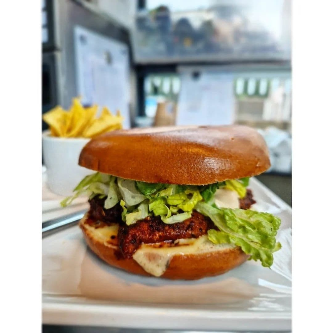 Juicy burger with lettuce on a brioche bun served with fries at Sociable Folk.