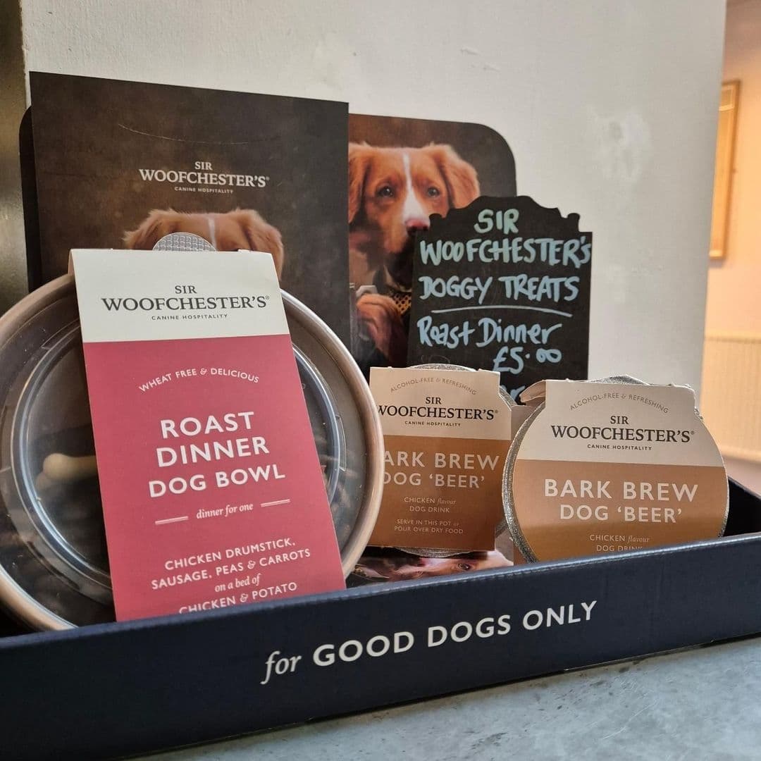 Alt text: "Pet-friendly offerings at The Tetley featuring Sir Woofchester's dog menu with a Roast Dinner Dog Bowl and Bark Brew 'Beer', set against a backdrop of promotional images with a dog."