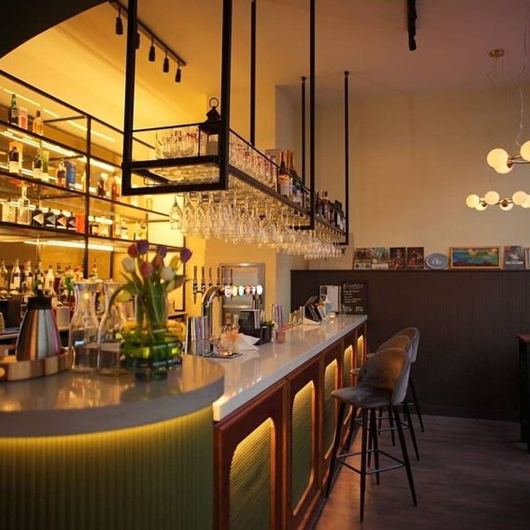Interior of OHANA bar with warm lighting, showcasing a well-stocked bar shelf, elegant glassware, and comfortable bar stools.