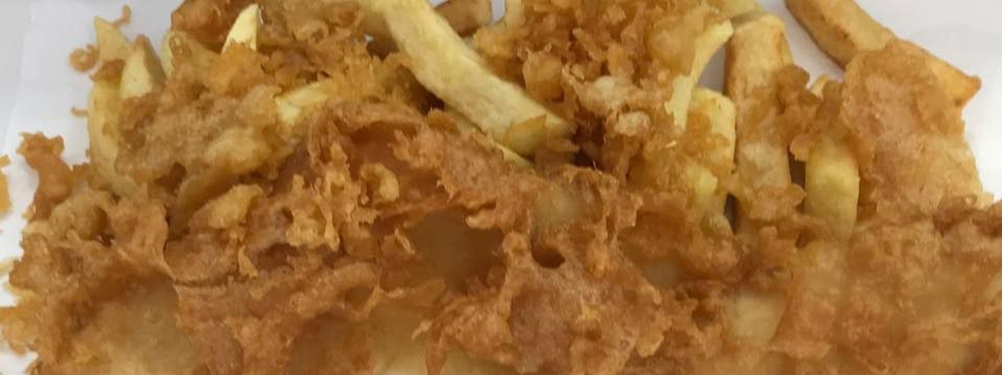 Plate of crispy battered fish and golden chips served at Ideal Fisheries.