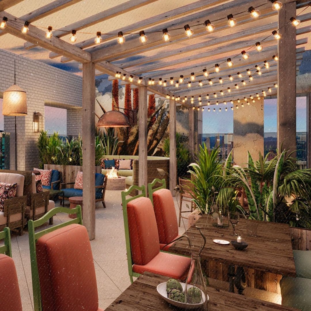 Alt text: A cozy rooftop terrace at Azotea featuring wooden beams, string lights, and comfortable seating. The space is adorned with plants and colorful cushions, creating a relaxing atmosphere for visitors.