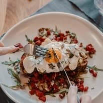 A beautifully plated dish featuring a poached egg on toast, garnished with diced tomatoes and herbs, ready to be enjoyed.