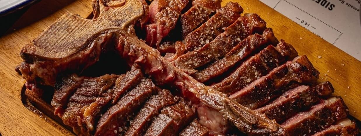 Juicy, perfectly cooked steak slices on a wooden board, garnished with coarse salt, exuding a rich, savory aroma.