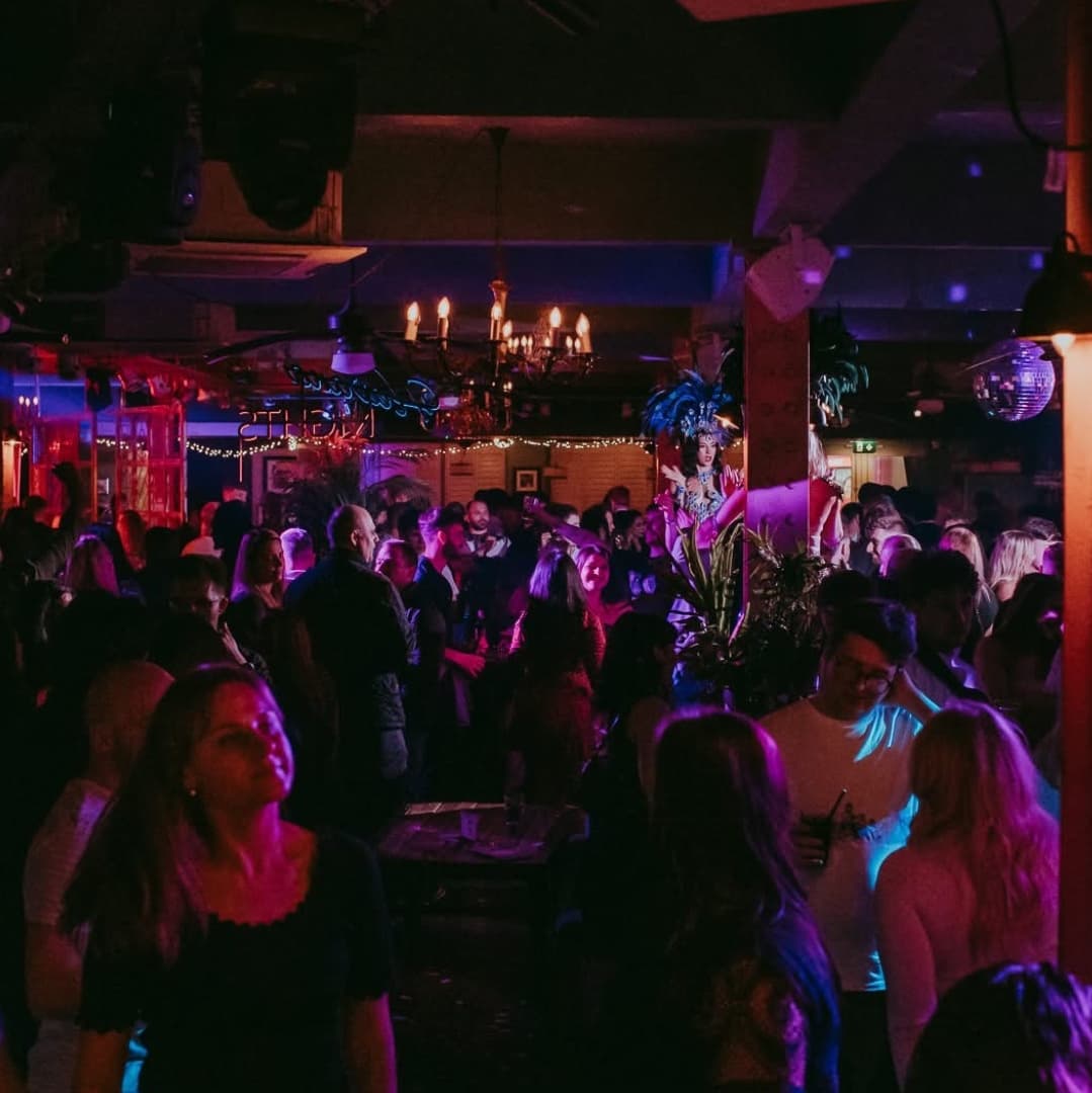 Vibrant nightlife scene at Revolución de Cuba Leeds, with a lively crowd, colorful lights, and tropical decor.