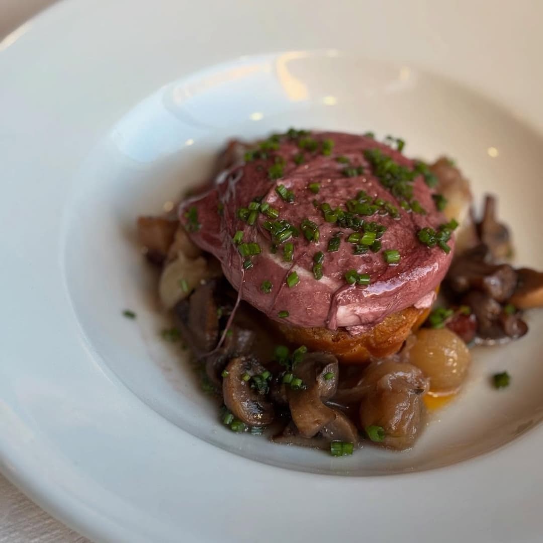 Tender beef fillet topped with fresh chives, served on a bed of sautéed mushrooms and caramelized onions.