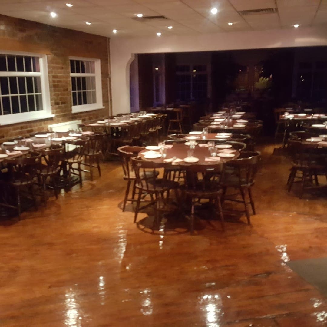 Akmal's Tandoori Bistro — empty dining room with brick walls and wooden tables