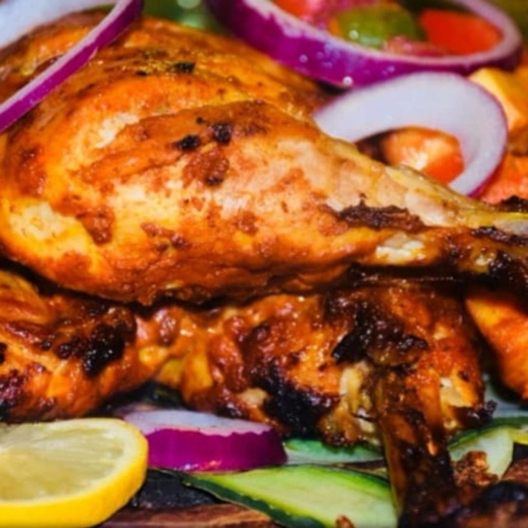Akmal's Tandoori Bistro — whole tandoori chicken with garnish