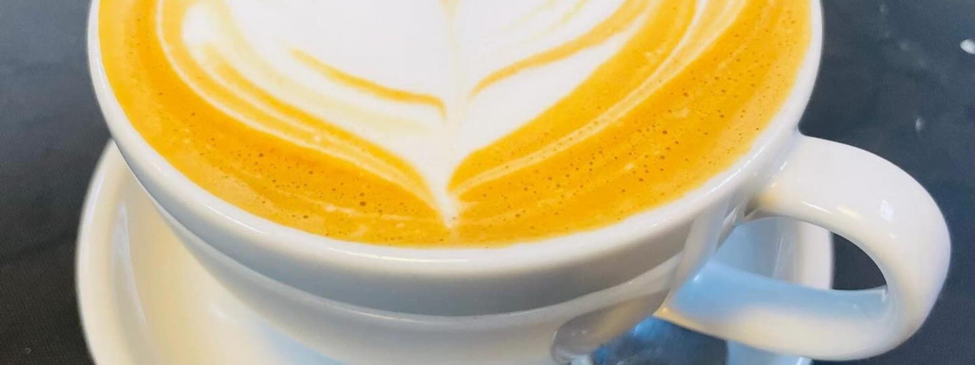Aromatik — golden latte with heart leaf art