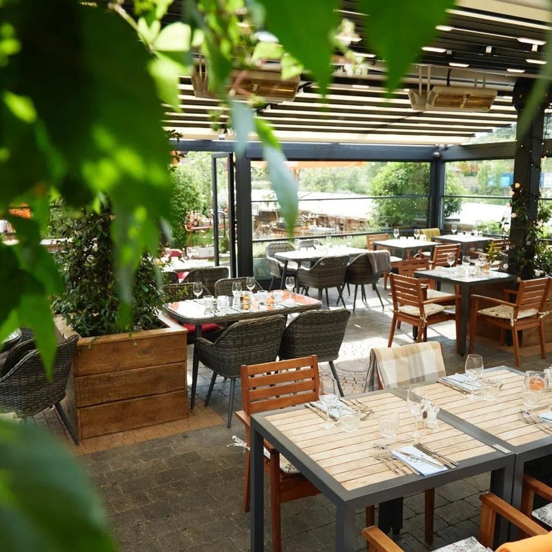 Buon Apps River Lounge — open-air conservatory terrace dining room with greenery
