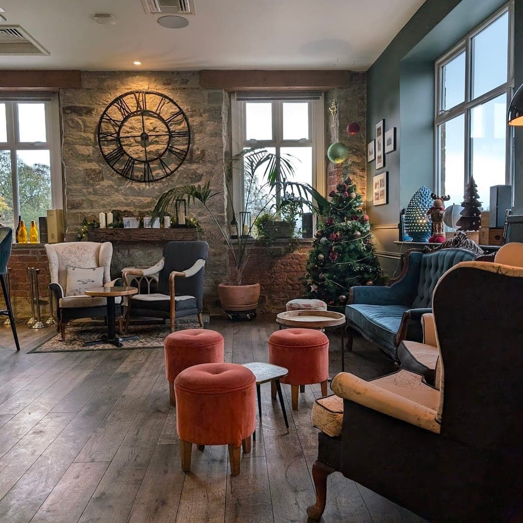 Buon Apps River Lounge — cosy lounge area with exposed stone walls and vintage clock