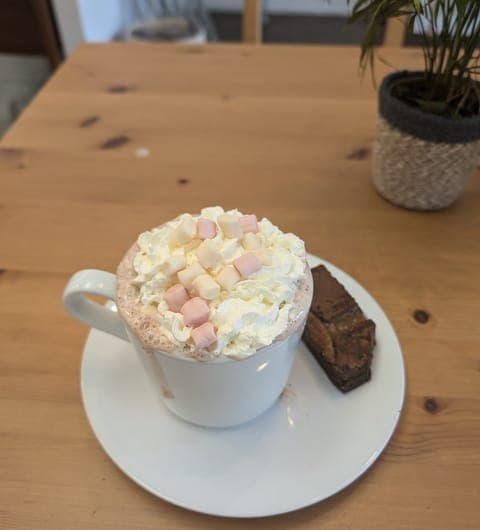 Hot chocolate with cream and marshmallows served with a brownie at 21 Co. Headingley