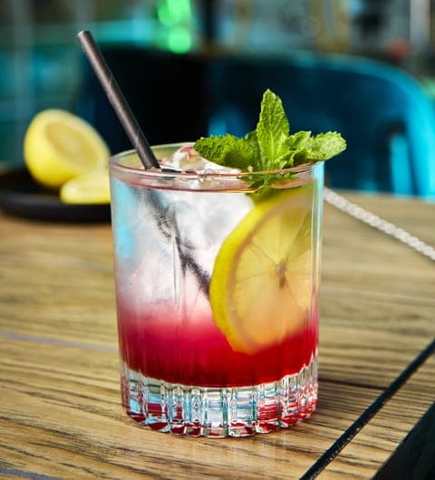 Layered berry cocktail with lemon slice and fresh mint at Caffeine Addict Headingley Leeds