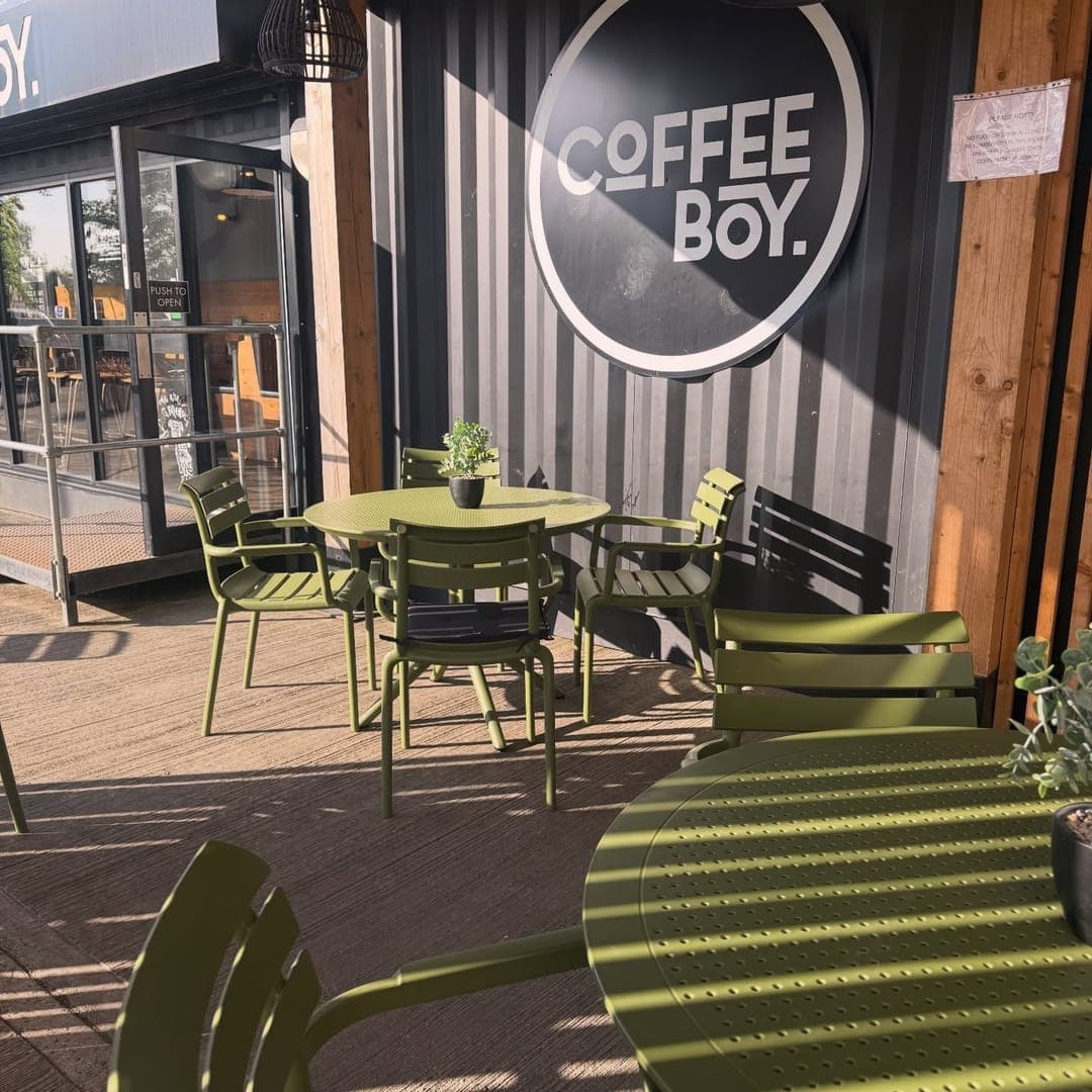 Coffeeboy Headingley outdoor seating area with lime green chairs and Coffeeboy logo signage